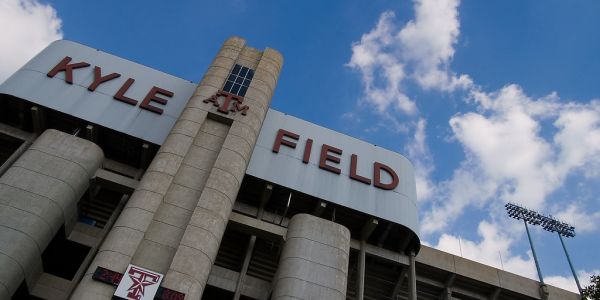 Exterior view of Kyle Field stadium with a blue sky and clouds near The Arbors at Wolf Pen Creek Apartments.